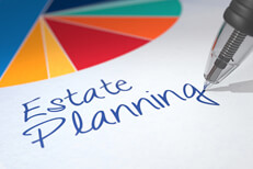 Colorful pie chart on paper with ballpoint pen writing Estate Planning beneath