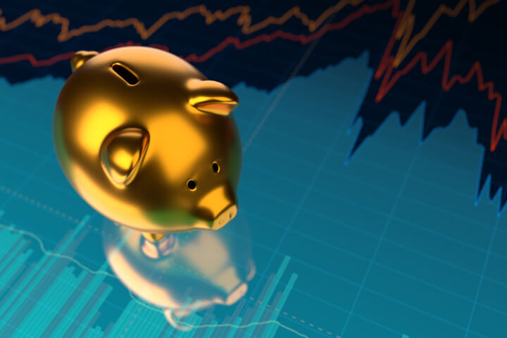Shiny gold metallic piggy bank on stock price area chart with glossy surface reflection