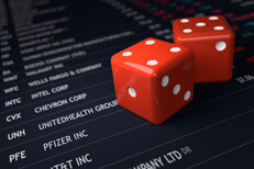 Stock ticker with dice Two red dice on top of stock exchange listings concept for investment risk