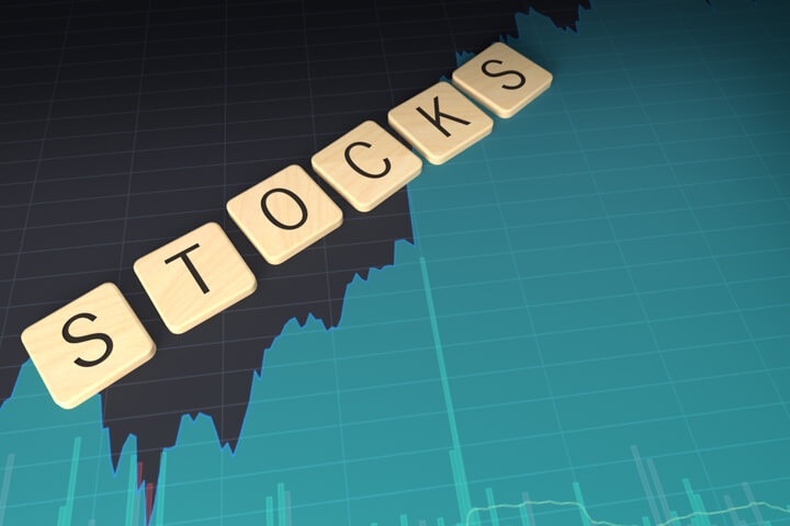 Scrabble-like wood letters spelling STOCKS laying on stock price area chart