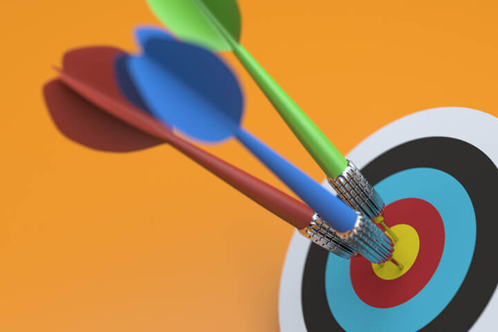 Three darts all hit the bulls eye of a target on white background