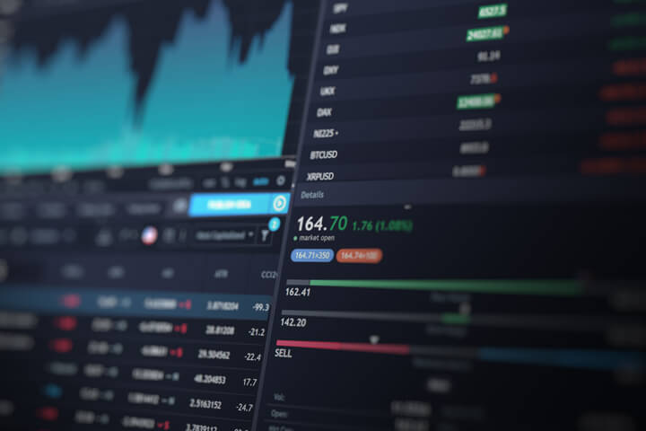 Computer screen showing stock data including price area chart, stock listings, and market capitalization
