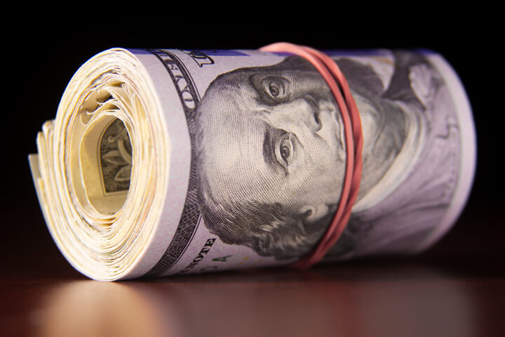 Roll of 100 dollar bills reflected