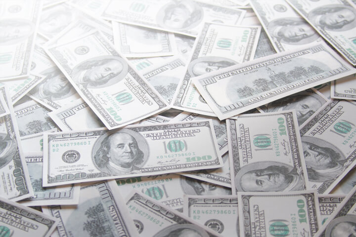 Scattered 100 dollar bills with corner highlight