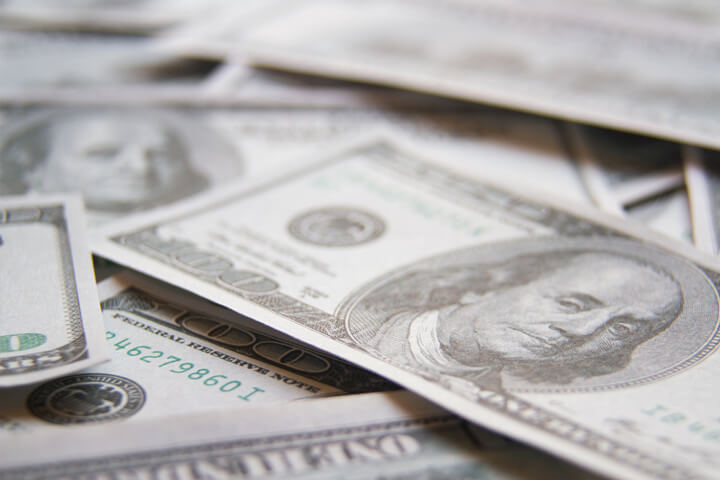 Scattered 100 dollar bills with shallow depth of field blur