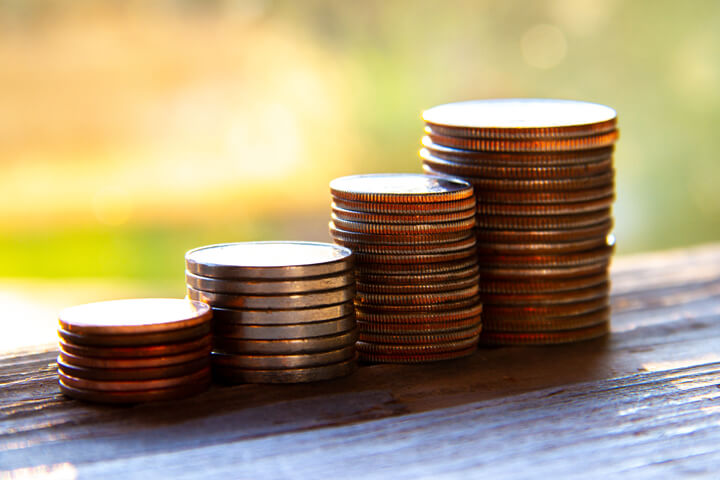 Stacks of pennies, nickels, dimes, and quarters in morning light