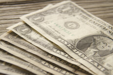 Free photo of dollar bills fanned out on wood background