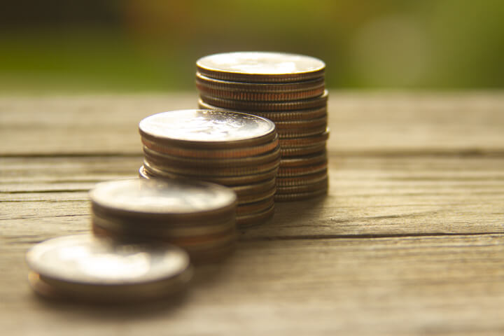Free photo of increasing stacks of quarters with background bokeh angled view
