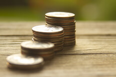 Free photo of increasing stacks of quarters with background bokeh angled view