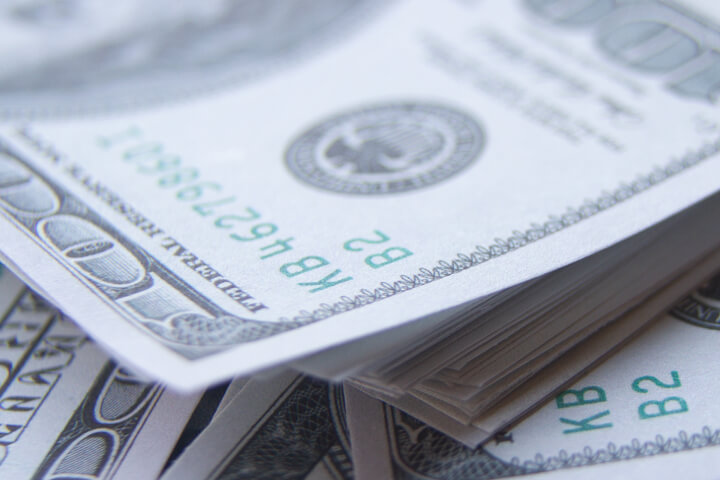 Large stack of $100 bills scattered