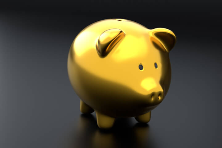Metallic gold piggy bank isolated on dark background
