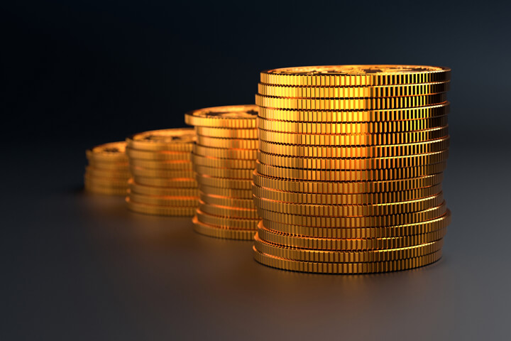 Column chart stack of gold coins on dark background showing value increase or compound interest