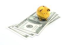 Gold piggy bank on top of Benjamins isolated on white background concept for savings, wealth, cost, or retirement