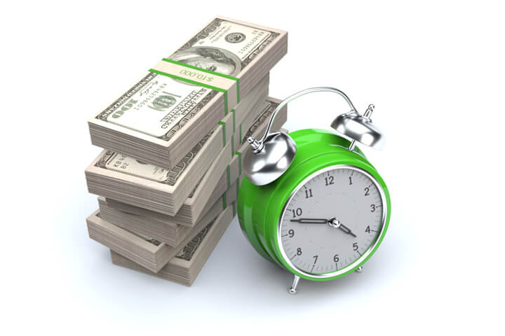 Concept image of clock and large stack of 100 dollar US bills representing savings, time is money, or time value of money