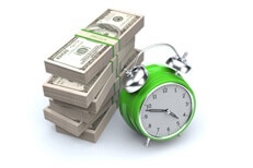 Concept image of clock and large stack of 100 dollar US bills representing savings, time is money, or time value of money