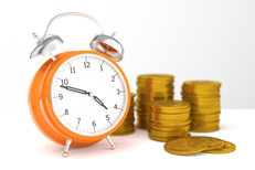 Concept of orange clock with stacks of U.S. gold coins