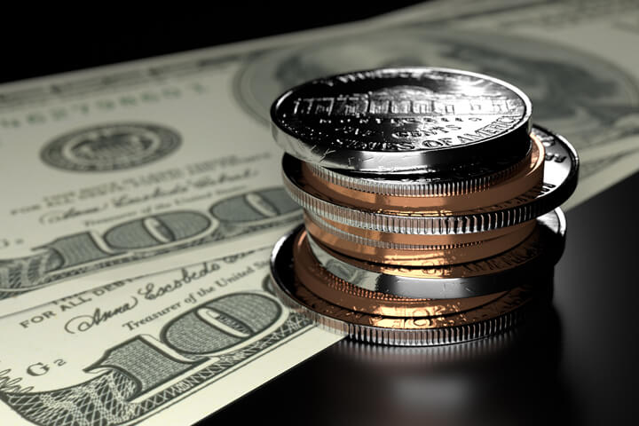Small stack of assorted U.S. coins on two one hundred dollar bills