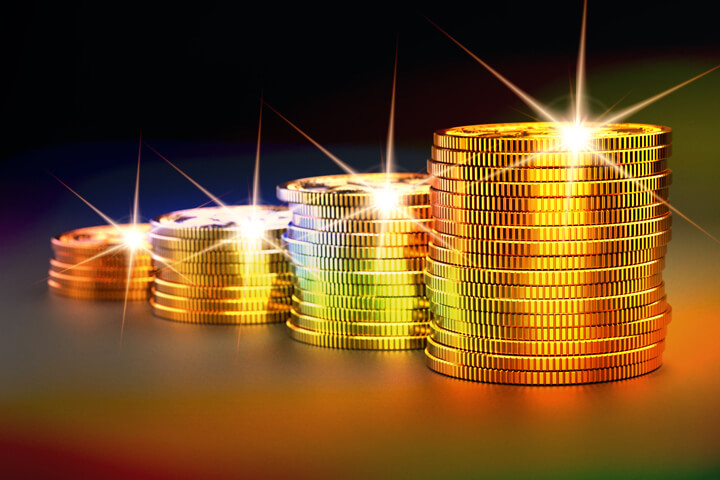 Stacks of gold coins increasing size representing investment gains over time with multiple light effects