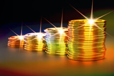 Stacks of gold coins increasing size representing investment gains over time with multiple light effects