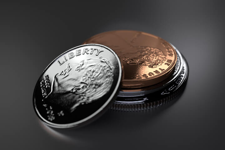Stack of U.S. coins with dime leaning against rest of stack dark background