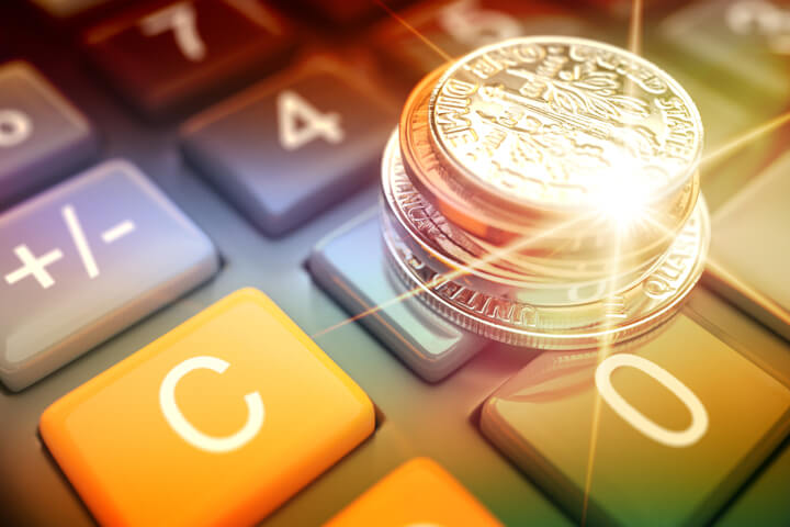 Stack of U.S. coins on calculator with lighting flare and overlay effect