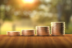 Four stacks of coins increasing to show investment growth