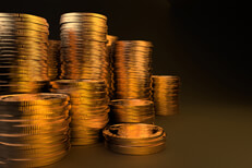 Many large stacks of gold coins on dark background with gold lighting