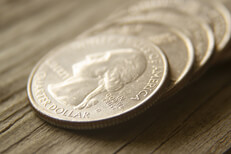 Row of quarter coins laid on wood background
