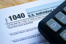 Photo showing 1040 IRS tax form and corner of calculator on desk