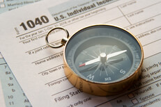 Tax help concept photo showing IRS form 1040 with navigational compass