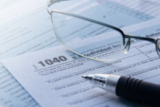 IRS form 1040 tax forms with reading glasses and ballpoint pen tax filing concept photo