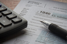 Calculator and ballpoint pen on IRS form 1040 paperwork