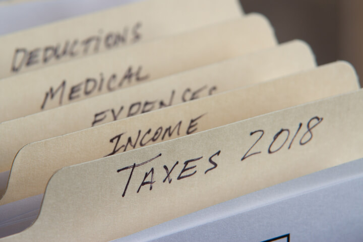 Manila folders in filing cabinet showing 2018 taxes and tax category folders