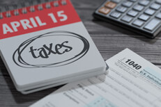 Spiral day calendar for April 15 showing word taxes circled