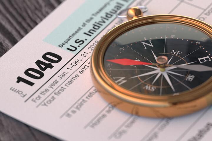 IRS form 1040 on wood background with navigation compass concept for tax help, direction, or advice