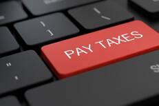 Laptop with Pay Taxes key Dark laptop keyboard with red Pay Taxes key concept photo