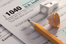 IRS form 1040 with yellow pencil, sharpener, and pencil shaving