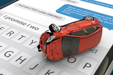 Text message accident concept Red car with rollover accident damage lying on cell phone screen with message app and keyboard open